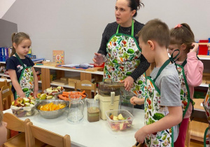 przedszkolaki przyglądają się jak wylatują resztki z owoców